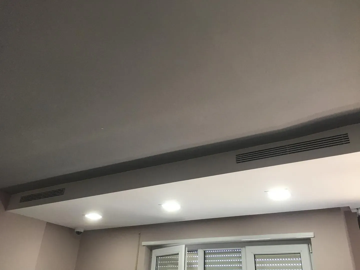 Grilë lineare ventilimi e integruar në tavanin e një dhome