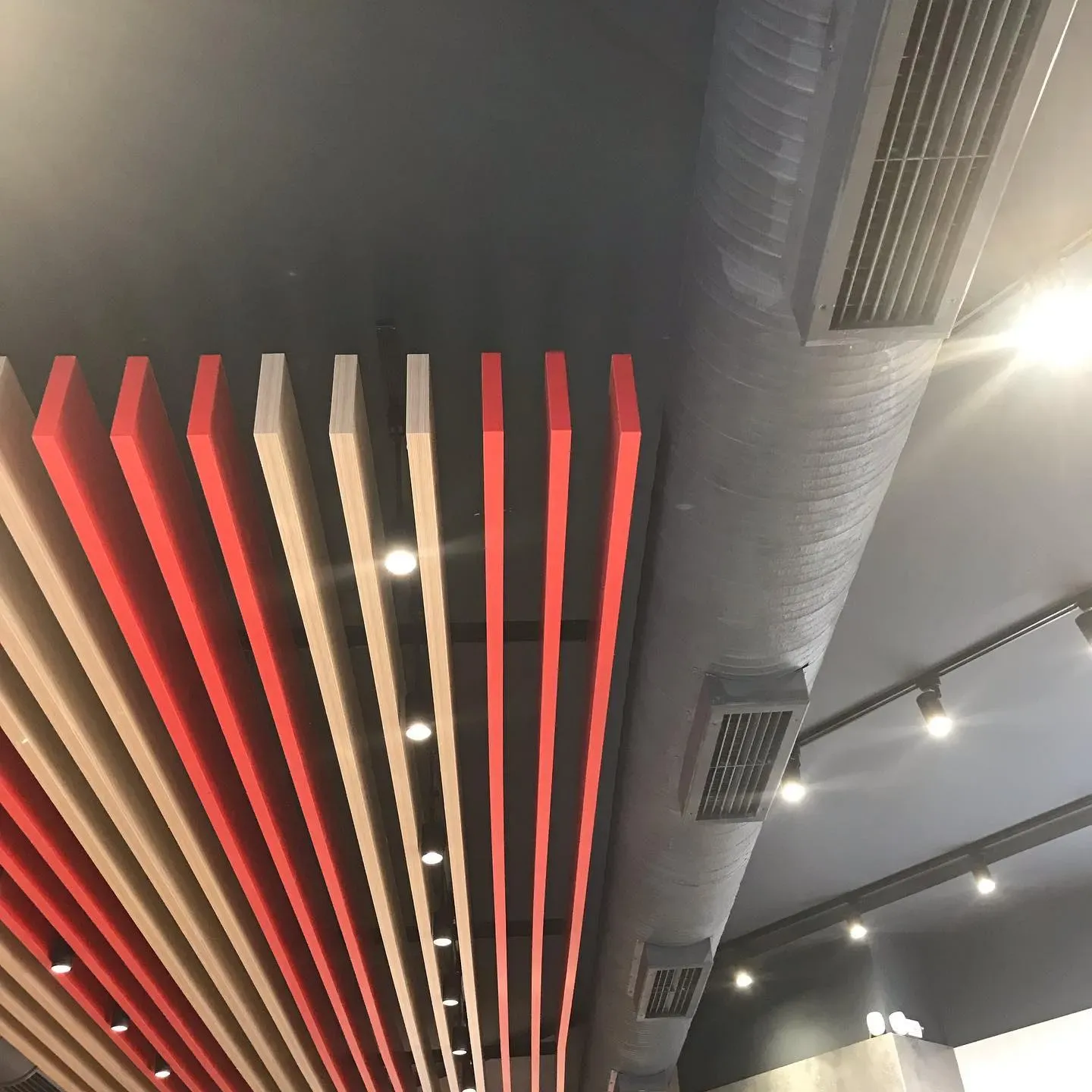 Grila ventilimi të integruara në tavan me lamela druri dhe të kuqe