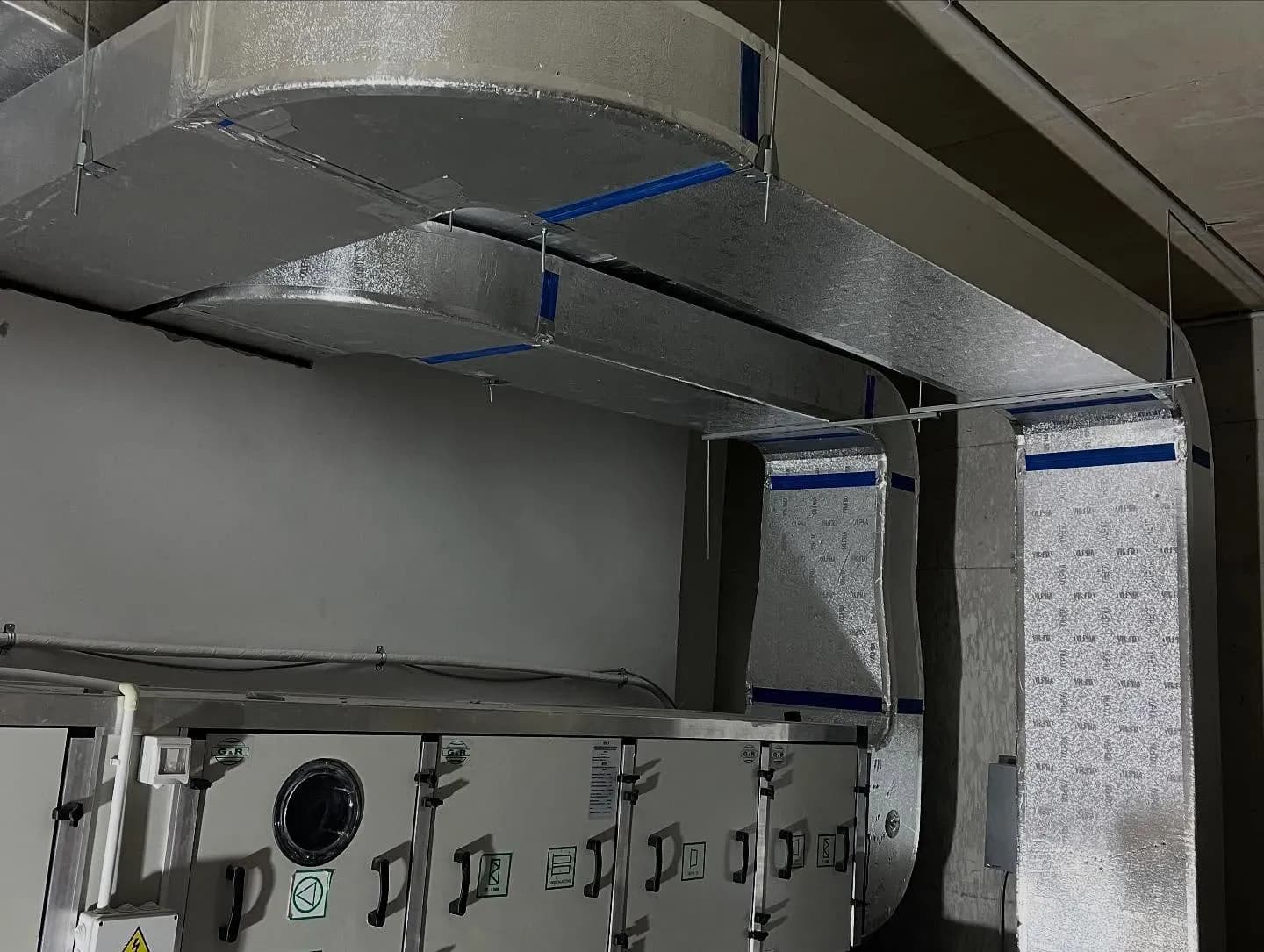 Kanale ventilimi të izoluara të montuara në tavanin e një korridori teknik