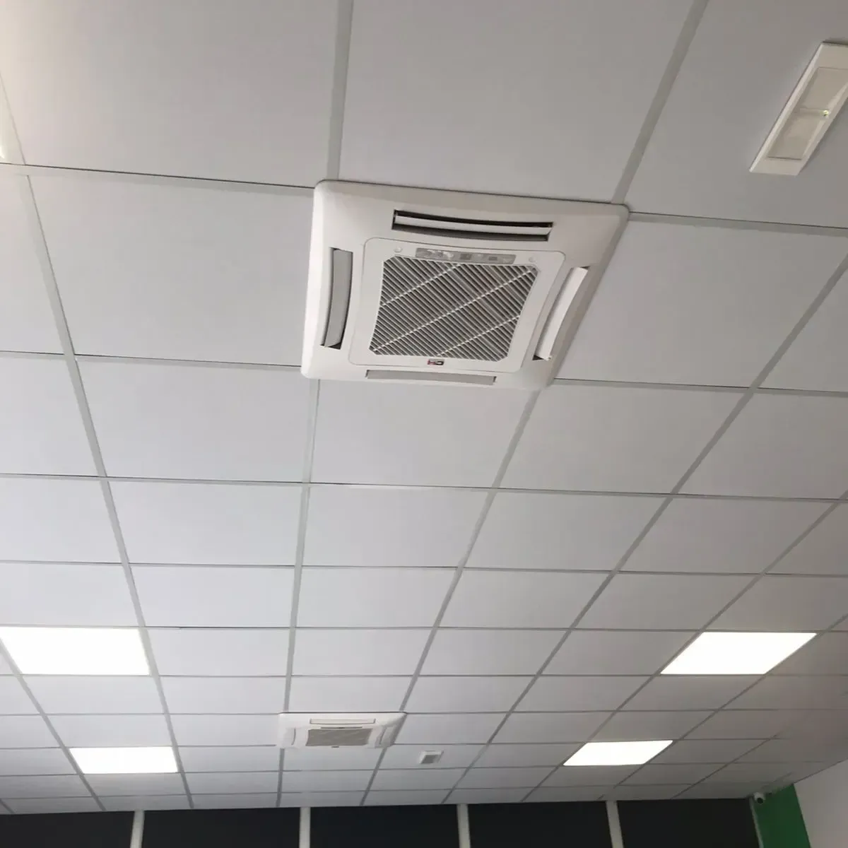 Kondicioner kasetë tavani i instaluar në tavanin e varur të një ambienti tregtar