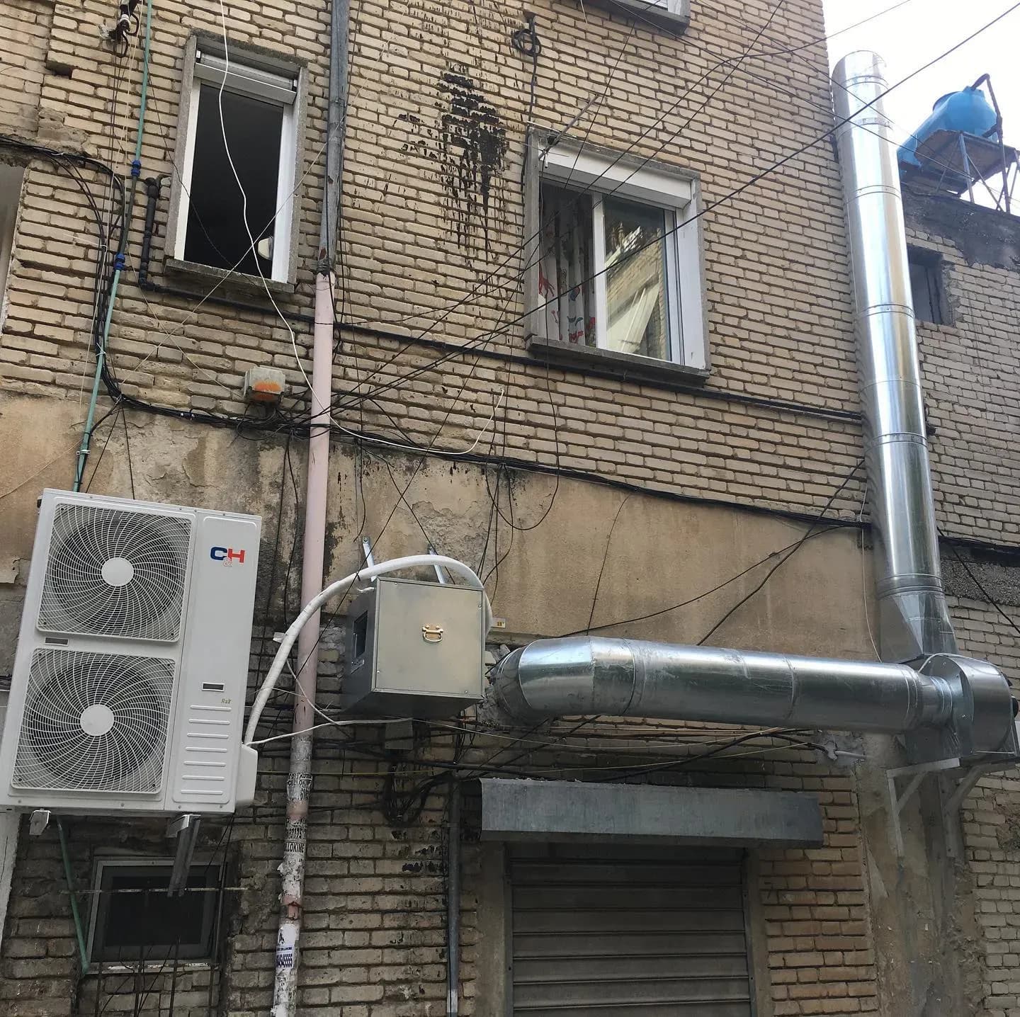 Njësi të jashtme dhe kanale ventilimi në fasadën e një pallati në Tiranë