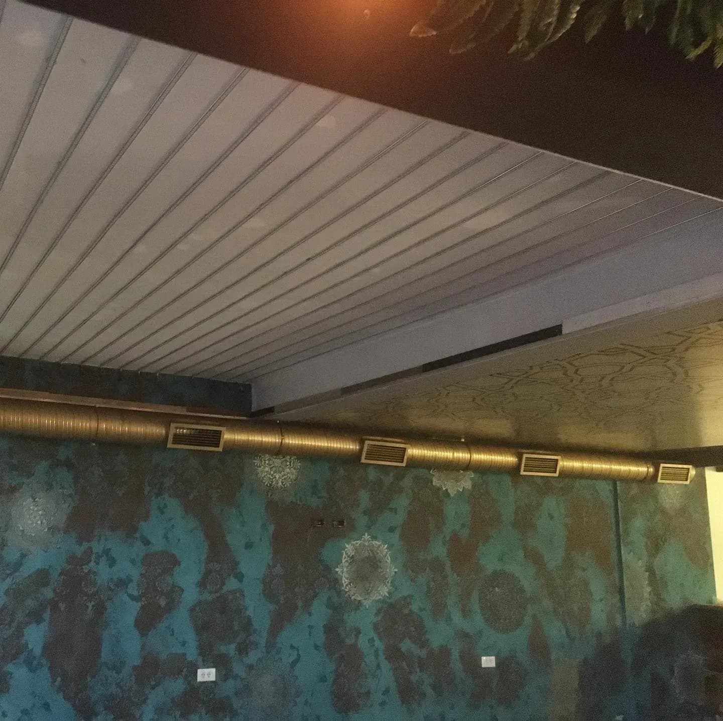 Ventilim me kanale të dukshme në tavanin e një restoranti
