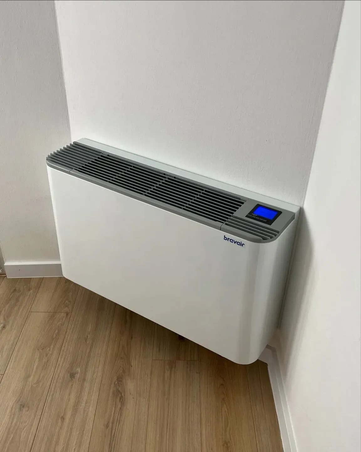 Ventilkonvektor dyshemeje i instaluar në një dhomë me parket